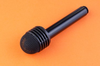 Turuncu arka plandaki eski bir kameradan mikrofon.