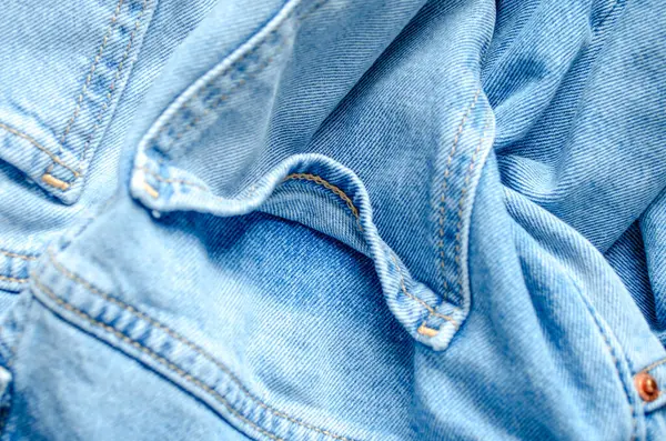 Buruşuk kot ceketli kumaşın doğal ışıkta yakın çekimi.