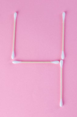 Tasarım veya zaman kavramı için pembe arkaplan üzerinde yaratıcı pamuk çubuk numaraları