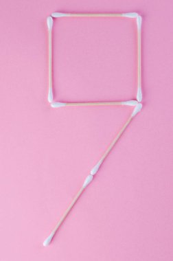 Tasarım veya zaman kavramı için pembe arkaplan üzerinde yaratıcı pamuk çubuk numaraları