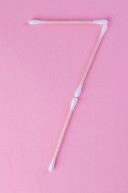 Tasarım veya zaman kavramı için pembe arkaplan üzerinde yaratıcı pamuk çubuk numaraları