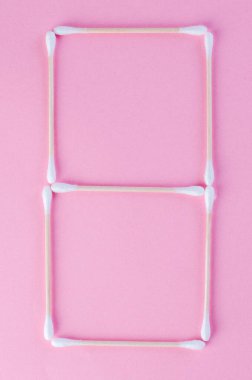 Tasarım veya zaman kavramı için pembe arkaplan üzerinde yaratıcı pamuk çubuk numaraları