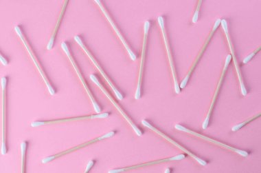 Pembe arka planda dağınık pamuklu çubuklar kaotik düzende