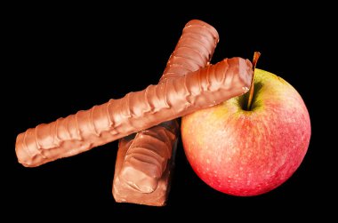 Meyve Çikolataya Karşı Karşılaştırma. Taze meyveler ve siyah arka planda cazip çikolatalar..