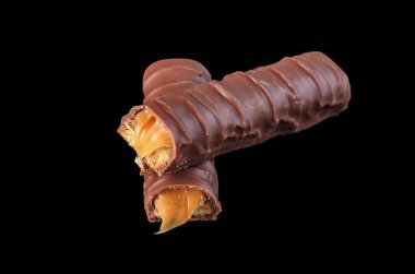 Siyah yüzeyde çikolatalı abur cubur, sağlıksız bir ikram.