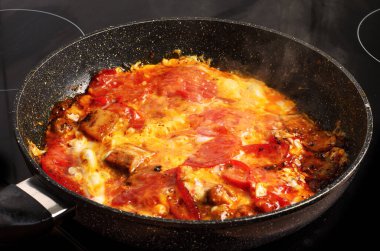 Pastırmalı yumurta ve tavada pişirilmiş domates.