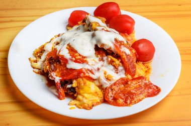 Beyaz tabakta mayonez ve domatesli ev yapımı yumurta.