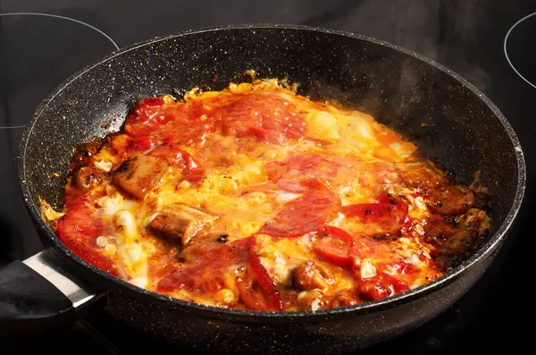 Pastırmalı yumurta ve tavada pişirilmiş domates.