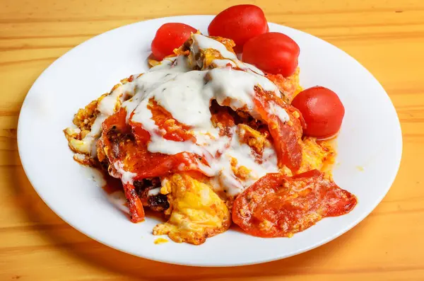 Beyaz tabakta mayonez ve domatesli ev yapımı yumurta.