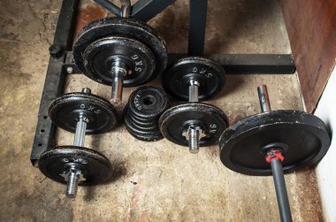 Boş ağırlıkları ve dambıl kalıplarıyla bodrum katındaki spor salonunda.