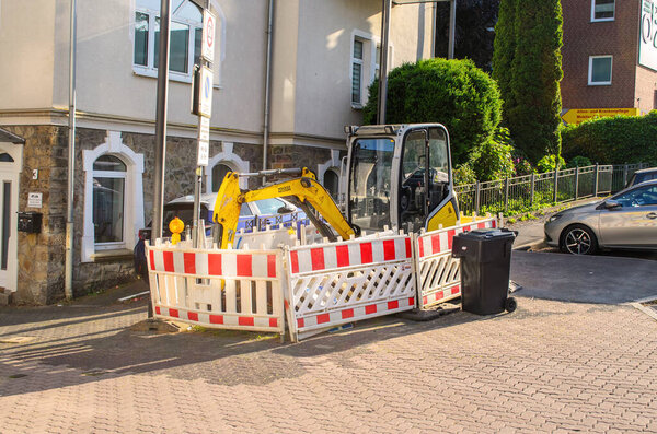 Street construction site with mini excavator and barriers in Iserlohn Germany June 2025