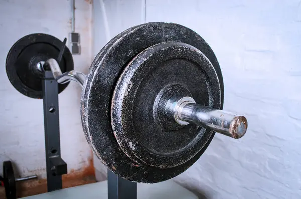 Bodrum katındaki spor salonundaki halterde, tuğladan arkaplanmış halter var.