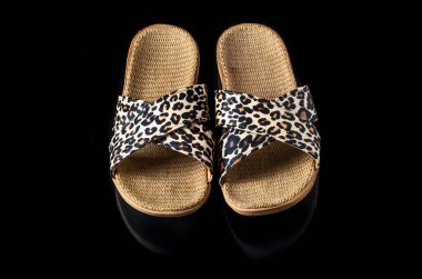 Siyah arka planda görünür giysili gündelik kadın terlikleri. 