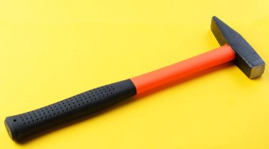 Sarı zemin üzerinde tek metal çekiç, üst görünüm, kopyalama alanı olan inşaat aracı