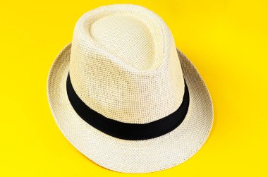 Parlak sarı arka planda izole edilmiş klasik plaj şapkası yaz moda aksesuarları.