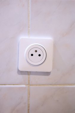 Bej kaplamalı duvar yüzeyindeki beyaz Avrupa elektrik prizini kapat