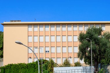 Şehir ortamında gün ışığı altında pencerelerde kapalı panjurlar olan bina