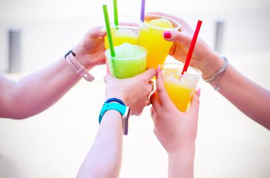 Kutlamada kadınların ellerinin plastik bardaklara içki ve pipetle vurması.