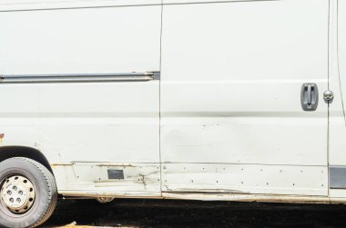 Çizikler, paslı lekeler ve eski bir arabanın yan tarafında hasar görmüş ve yıpranmış bir araç cesedi var.