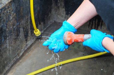 Elleri lastik eldivenlerle akan suyun altında yıkamak.