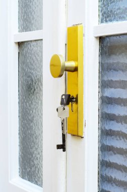 Giriş kapısının kilidinde asılı anahtarlar güvenlik ve erişim sembolünü kapat