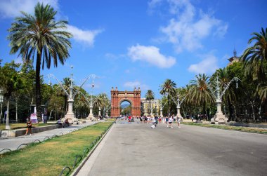 BARCELONA İSPA 23 HAZİRAN 2025 Parlak güneş ışığı altında triomf kavşağına doğru yürüyen turistler