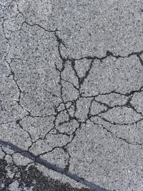 Yıpranmış asfalt kaldırıma yakın ciddi örümcek ağı çatlakları dokusu