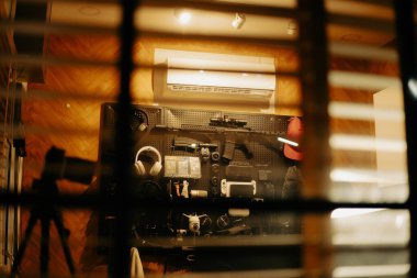 Pencere perdelerinden sinema masasına sessiz ve samimi bir bakış. Yumuşak, ılık ışıklar ve bulanık çizgiler nostaljik ve yansıtıcı bir atmosferi çağrıştırıyor..