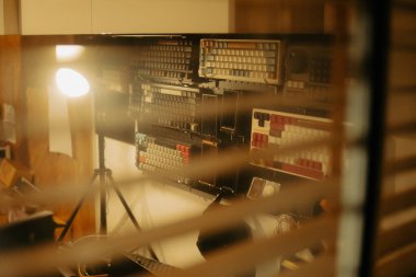 Pencere perdelerinden sinema masasına sessiz ve samimi bir bakış. Yumuşak, ılık ışıklar ve bulanık çizgiler nostaljik ve yansıtıcı bir atmosferi çağrıştırıyor..