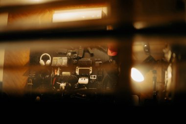 Pencere perdelerinden sinema masasına sessiz ve samimi bir bakış. Yumuşak, ılık ışıklar ve bulanık çizgiler nostaljik ve yansıtıcı bir atmosferi çağrıştırıyor..