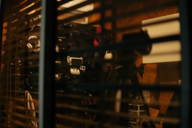 Pencere perdelerinden sinema masasına sessiz ve samimi bir bakış. Yumuşak, ılık ışıklar ve bulanık çizgiler nostaljik ve yansıtıcı bir atmosferi çağrıştırıyor..