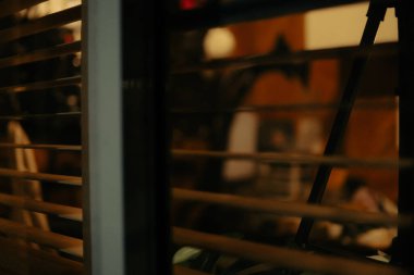 Pencere perdelerinden sinema masasına sessiz ve samimi bir bakış. Yumuşak, ılık ışıklar ve bulanık çizgiler nostaljik ve yansıtıcı bir atmosferi çağrıştırıyor..