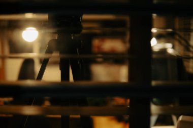 Pencere perdelerinden sinema masasına sessiz ve samimi bir bakış. Yumuşak, ılık ışıklar ve bulanık çizgiler nostaljik ve yansıtıcı bir atmosferi çağrıştırıyor..