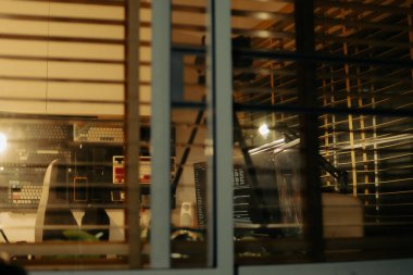 Pencere perdelerinden sinema masasına sessiz ve samimi bir bakış. Yumuşak, ılık ışıklar ve bulanık çizgiler nostaljik ve yansıtıcı bir atmosferi çağrıştırıyor..