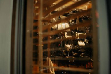 Pencere perdelerinden sinema masasına sessiz ve samimi bir bakış. Yumuşak, ılık ışıklar ve bulanık çizgiler nostaljik ve yansıtıcı bir atmosferi çağrıştırıyor..