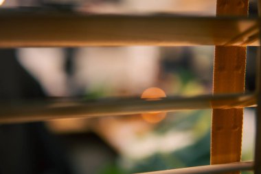 Üç monitör, not defteri, mikrofon ve yeşil bitkilerden oluşan sıcak ve rahat bir masa düzeni. Yaratıcı işler için minimalist bir Japon estetiğine sahip..