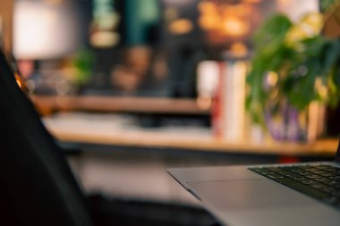 Üç monitör, not defteri, mikrofon ve yeşil bitkilerden oluşan sıcak ve rahat bir masa düzeni. Yaratıcı işler için minimalist bir Japon estetiğine sahip..