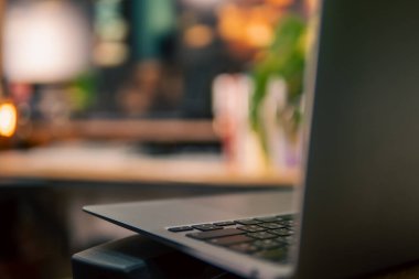 Üç monitör, not defteri, mikrofon ve yeşil bitkilerden oluşan sıcak ve rahat bir masa düzeni. Yaratıcı işler için minimalist bir Japon estetiğine sahip..