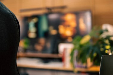 Üç monitör, not defteri, mikrofon ve yeşil bitkilerden oluşan sıcak ve rahat bir masa düzeni. Yaratıcı işler için minimalist bir Japon estetiğine sahip..