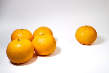 Olgun sulu portakallar, temiz beyaz bir arka planda, yaratıcı, natürmort yaşam kompozisyonlarında sıralanmıştır. Asgari ve ticari görünüm.