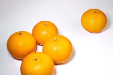 Olgun sulu portakallar, temiz beyaz bir arka planda, yaratıcı, natürmort yaşam kompozisyonlarında sıralanmıştır. Asgari ve ticari görünüm.