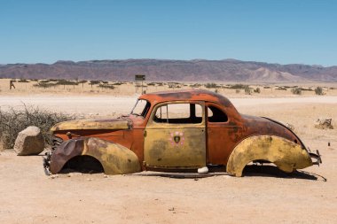 Çölün ortasında terk edilmiş eski bir araba.