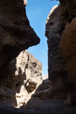 Büyük taşları ve mavi gökyüzü olan antik taş bir duvar..