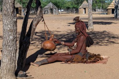Yaşlı adam köyde yerde oturuyor.