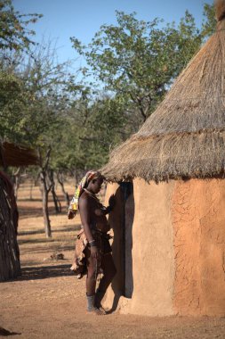 Köyde geleneksel elbisesi olan Afrikalı bir kadın.