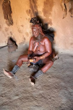 Siyah elbiseli ve çantalı bir adamın portresi.