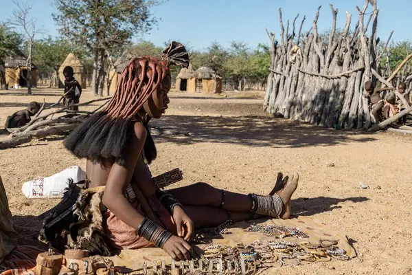 Etnik giyimli ve saman şapkalı Afro-Amerikan kadın köyde oturuyordu.