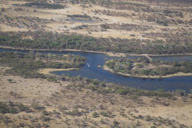 Ortasında ağaçlar olan güzel bir manzaranın havadan görünüşü.