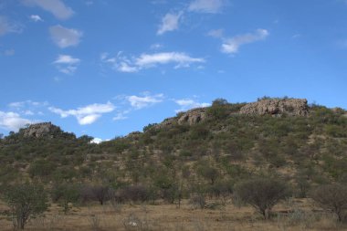 Dağları ve mavi gökyüzü olan güzel bir manzara.