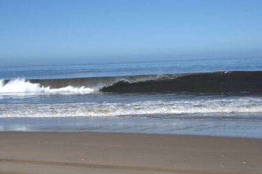 Bir sürü kumla sahile vuran dalgalar.